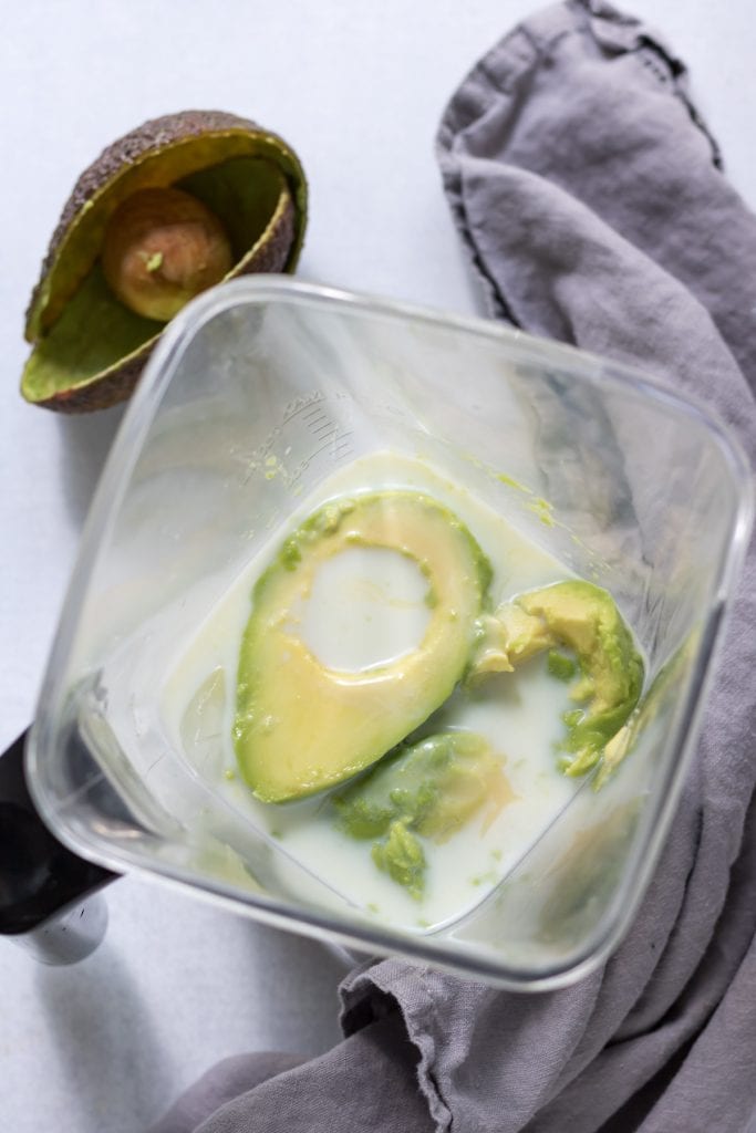 Avocado and milk in a blender.