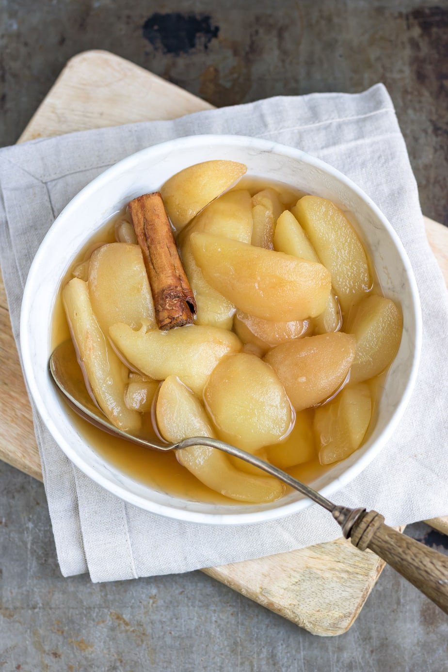 Bowl of stewed pears with a cinnamon stick.