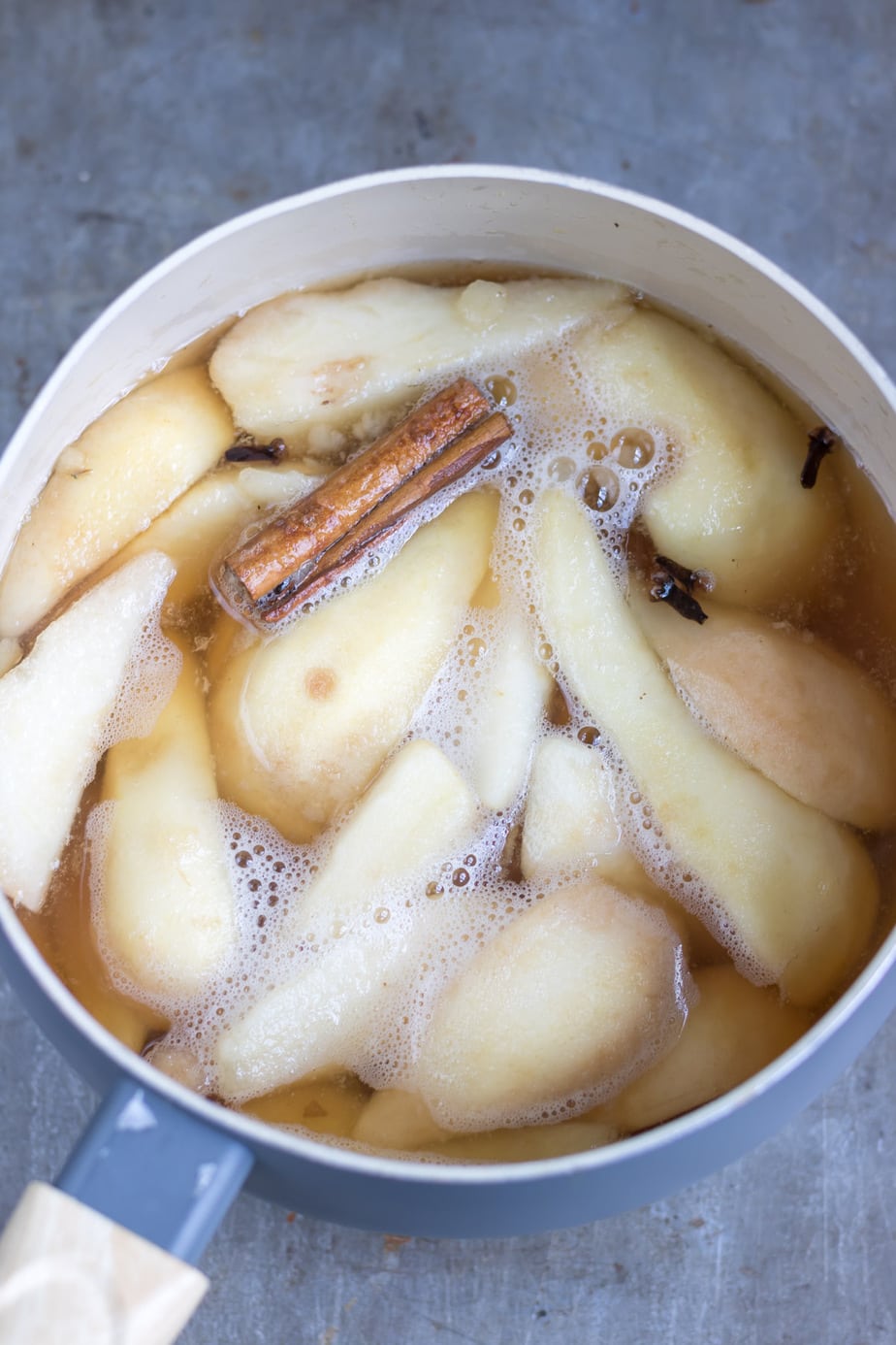 Pot of stewed pears with cinnamon stick and cloves.