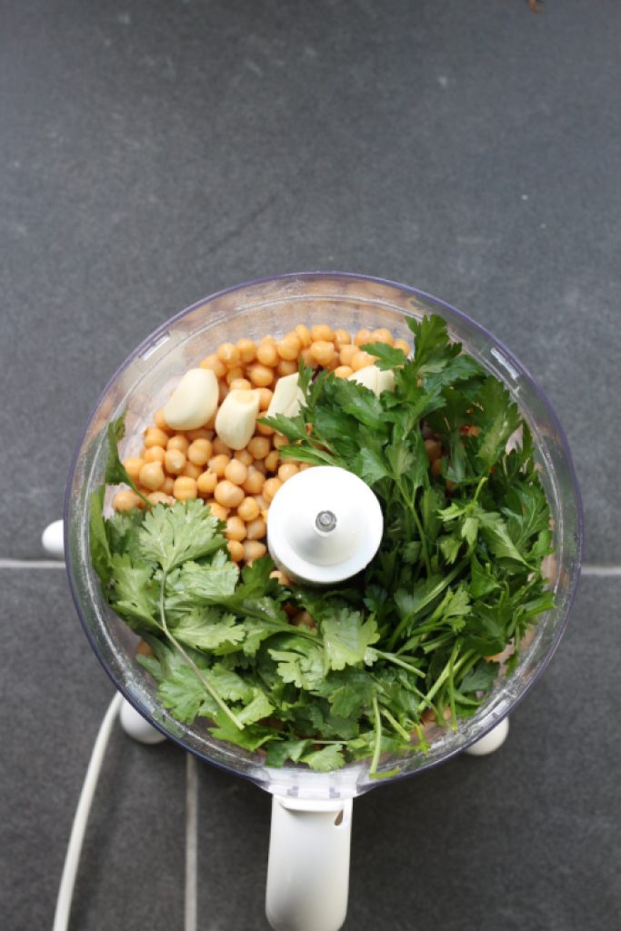 Food processor with chickpeas, garlic and herbs.