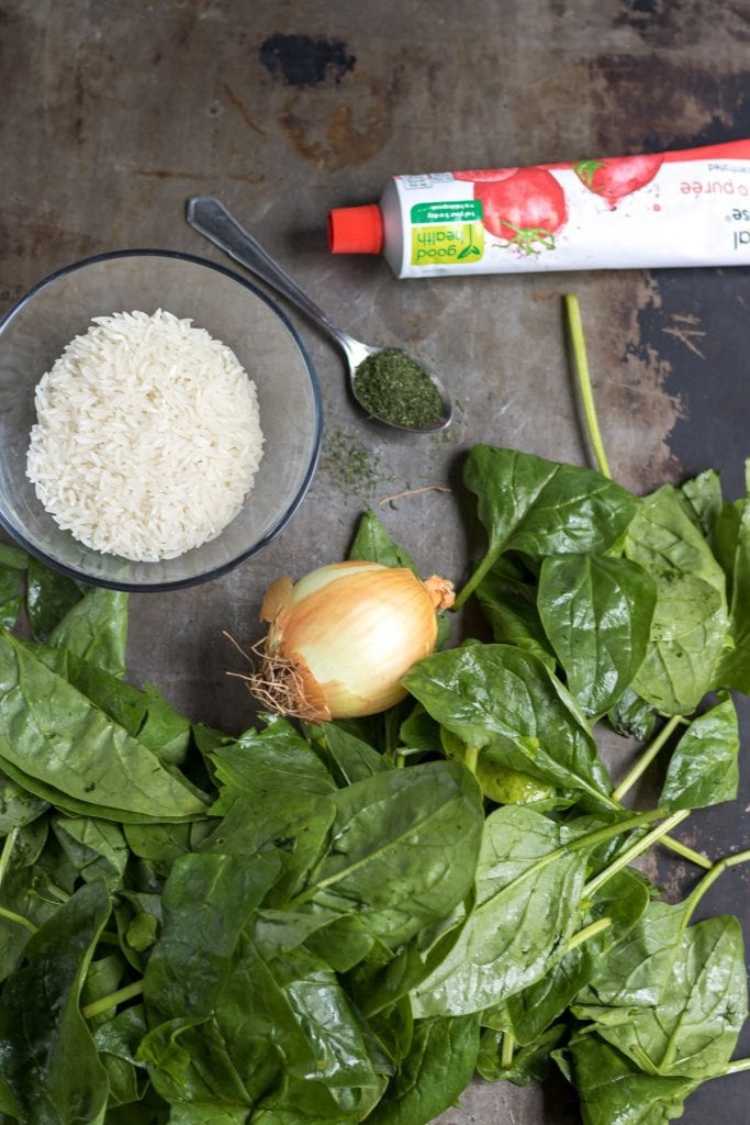 Spinach, onion, dill, rice, on a table.