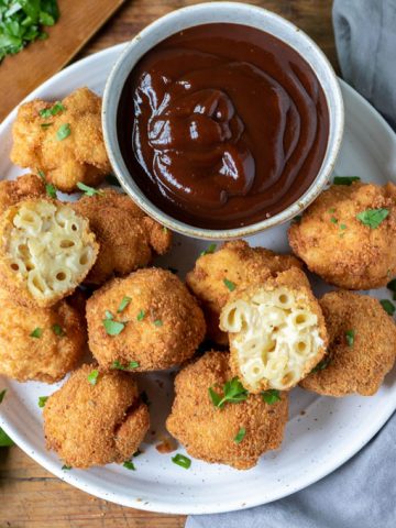 Plate of fried macaroni and cheese balls with bowl of barbecue sauce.