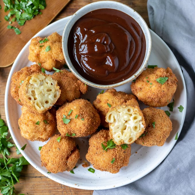 Plate of fried macaroni and cheese balls with bowl of barbecue sauce.