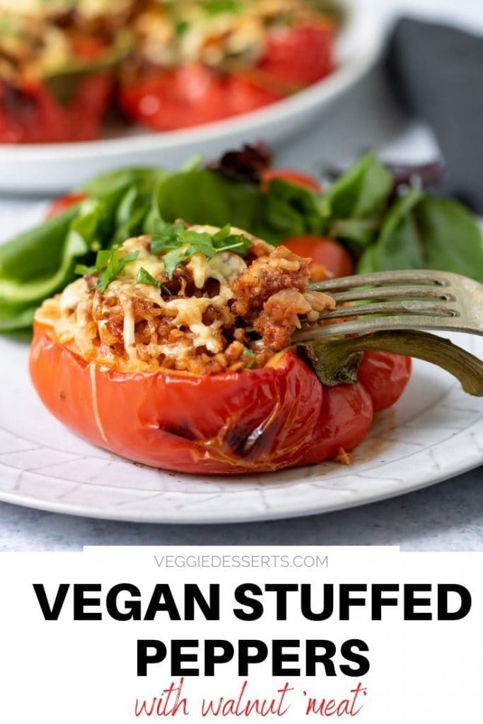 Stuffed pepper on a plate with salad. Text overlay reads: Vegan Stuffed Peppers with walnut meat.