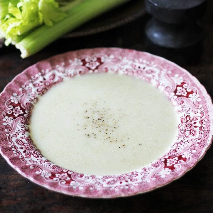 Vintage bowl of soup with celery in the background.