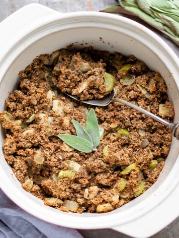 Casserole dish of vegan stuffing with sage on top.