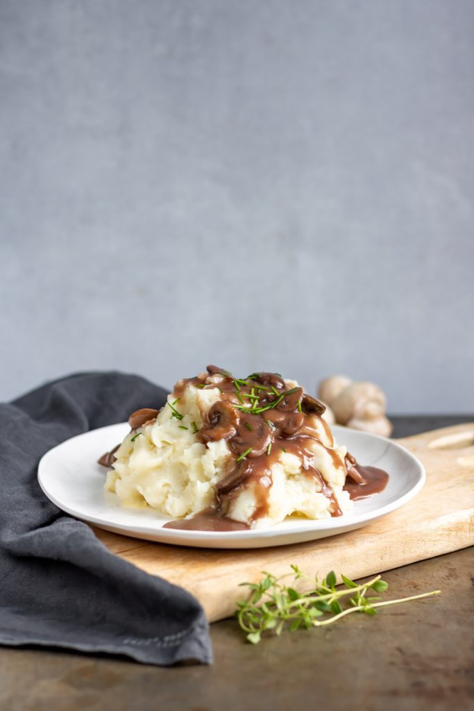 Plate of mashed potatoes with gravy.