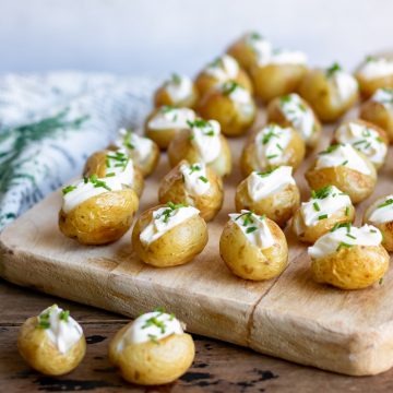 A serving board with mini baked potatoes.