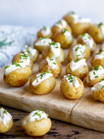 A serving board with mini baked potatoes.