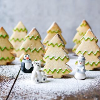 Tree shaped cookies stood up with powdered sugar snow.