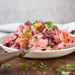 Dish of rosolli salad with a serving spoon.