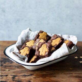 Enamel dish full of brownies topped with mini gingerbread men.