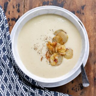 Bowl of soup next to a tea towel.
