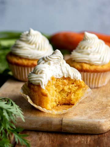 Pack up of a carrot cupcake with a bite out.  Apple Parsnip Cupcakes with Boozy Apple Ci carrot cupcakes 5sq2 360x480