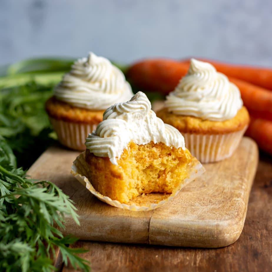 Close up of a carrot cupcake with a bite out.