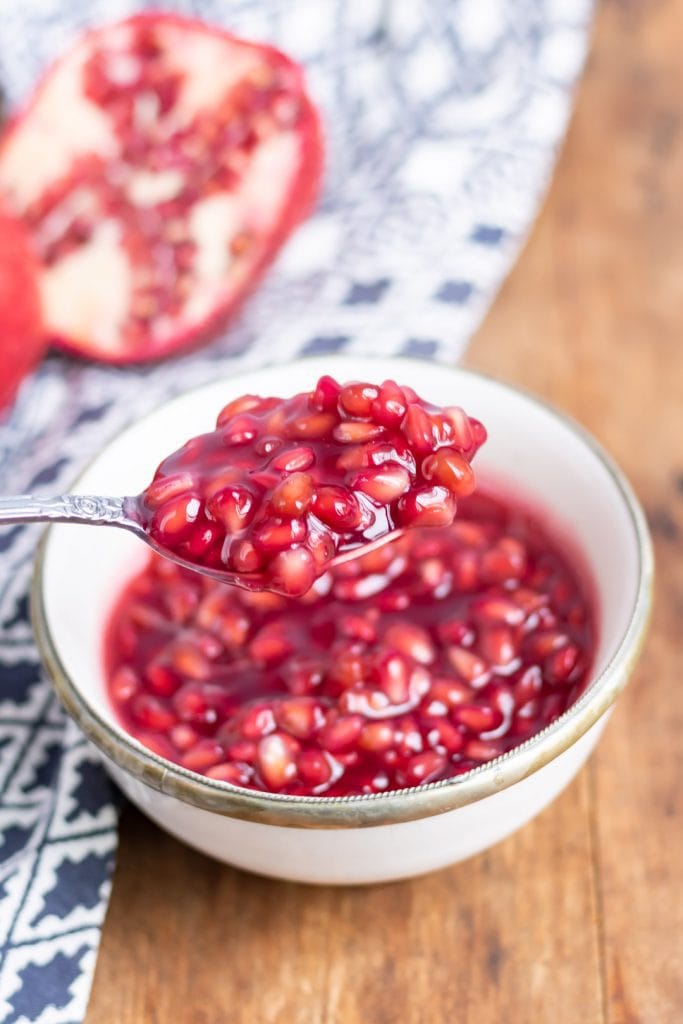 Spoonful over a bowl of pomegranate compote.