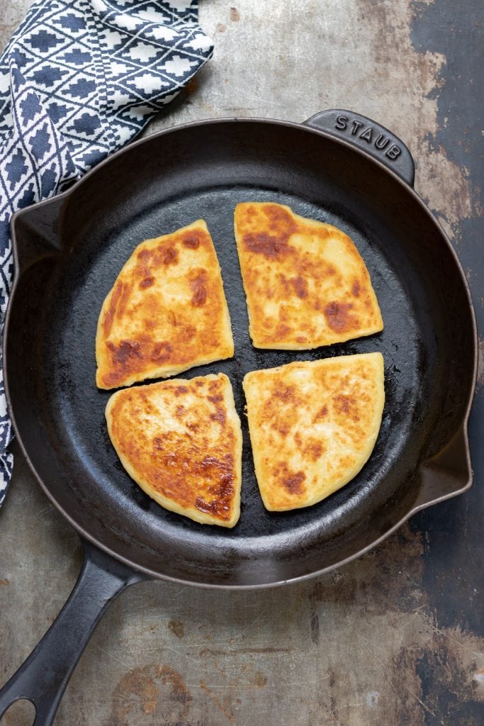 Skillet with cooked potato farls.