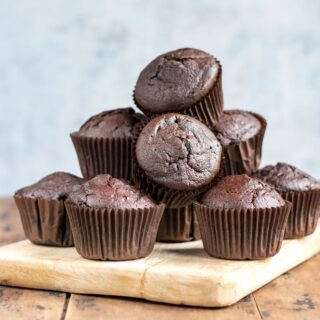 Pile of chocolate beetroot muffins on a board.
