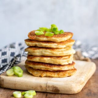 Stack of boxty with scallions on top.
