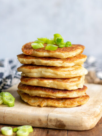 Stack of boxty with scallions on top.