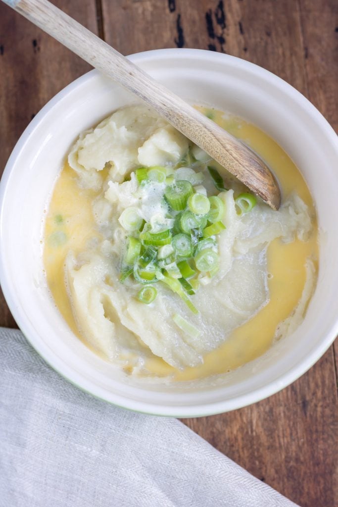 Bowl of mashed potatoes with scallions and milk added.