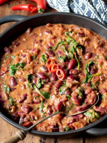 Close up of a kidney bean and spinach curry in a serving dish.