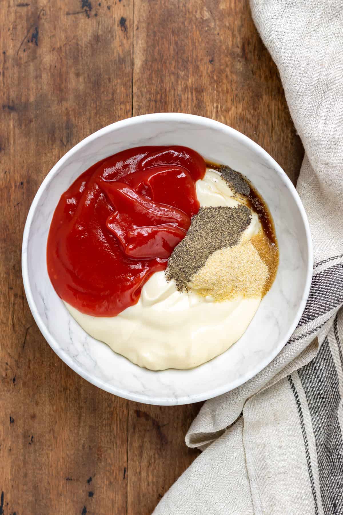 Bowl of mayo, ketchup, garlic powder, vinegar, worcestershire sauce and pepper.