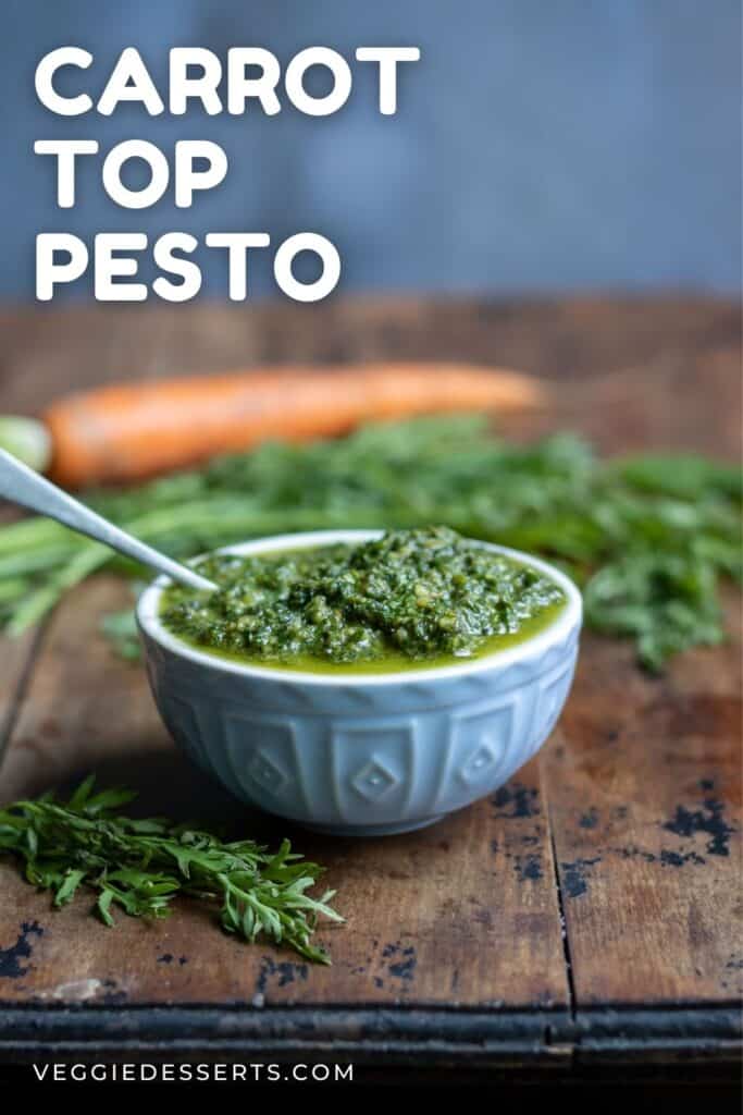Dish of pesto on a wooden table with text: Carrot Top Pesto.