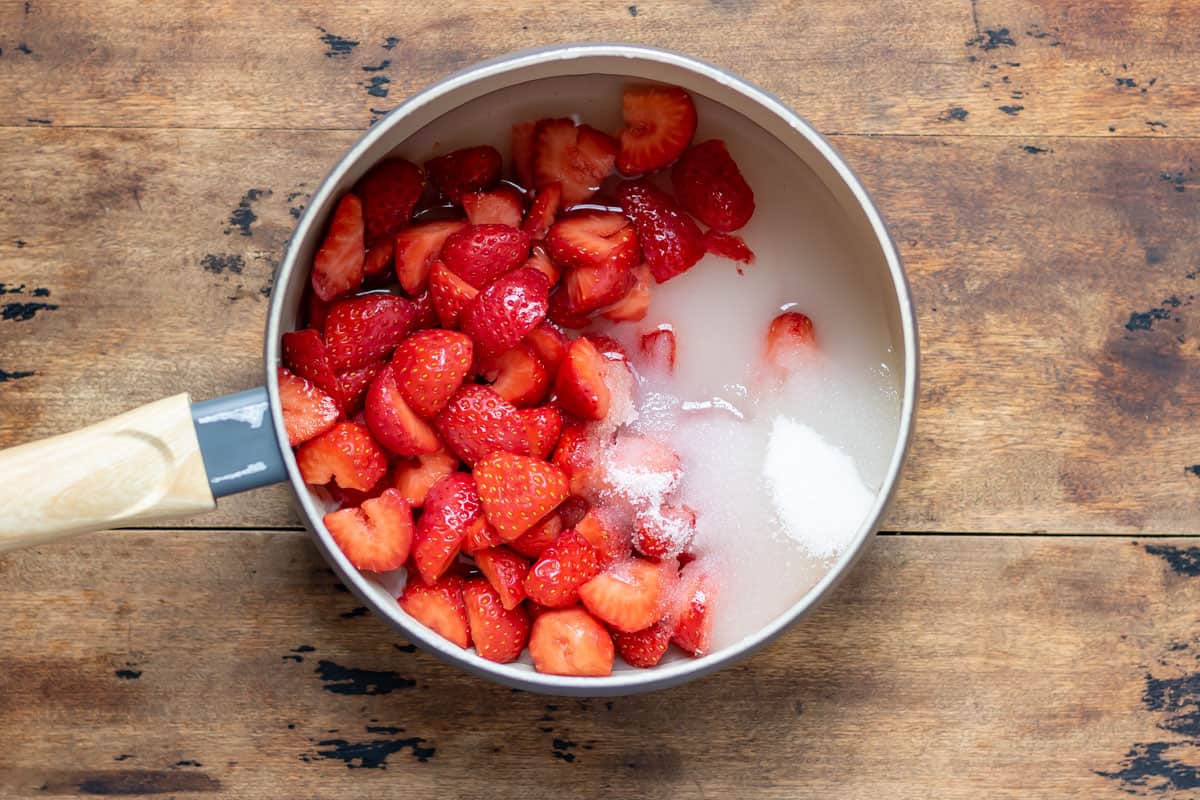 Pan with strawberries, water, sugar and vanilla.