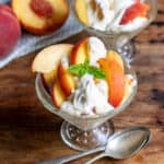 Glass dishes with peaches drizzled in a vanilla cream.