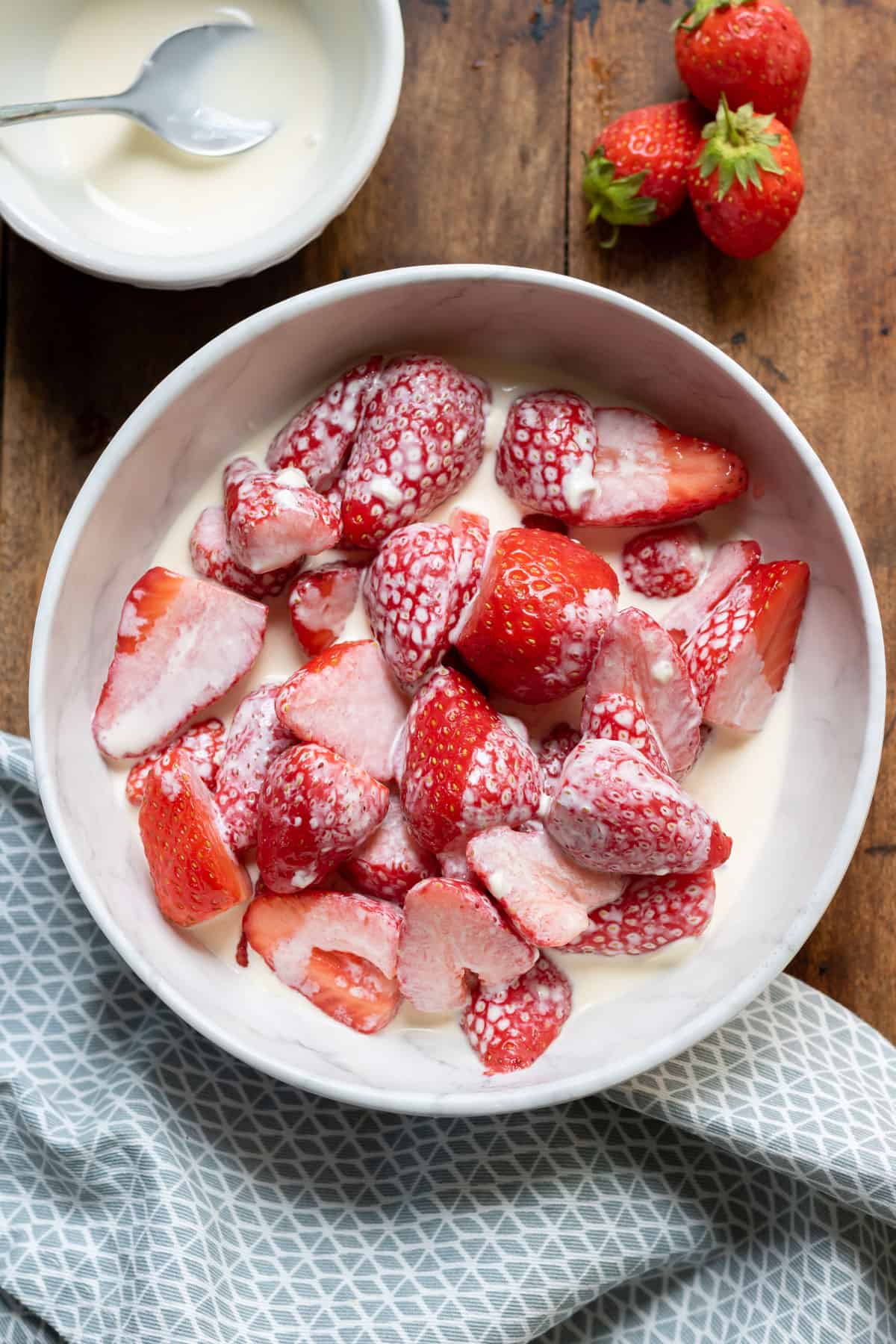 Bowl of cream and strawberries.