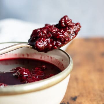 Spoonful of blackberry compote on a bowl.