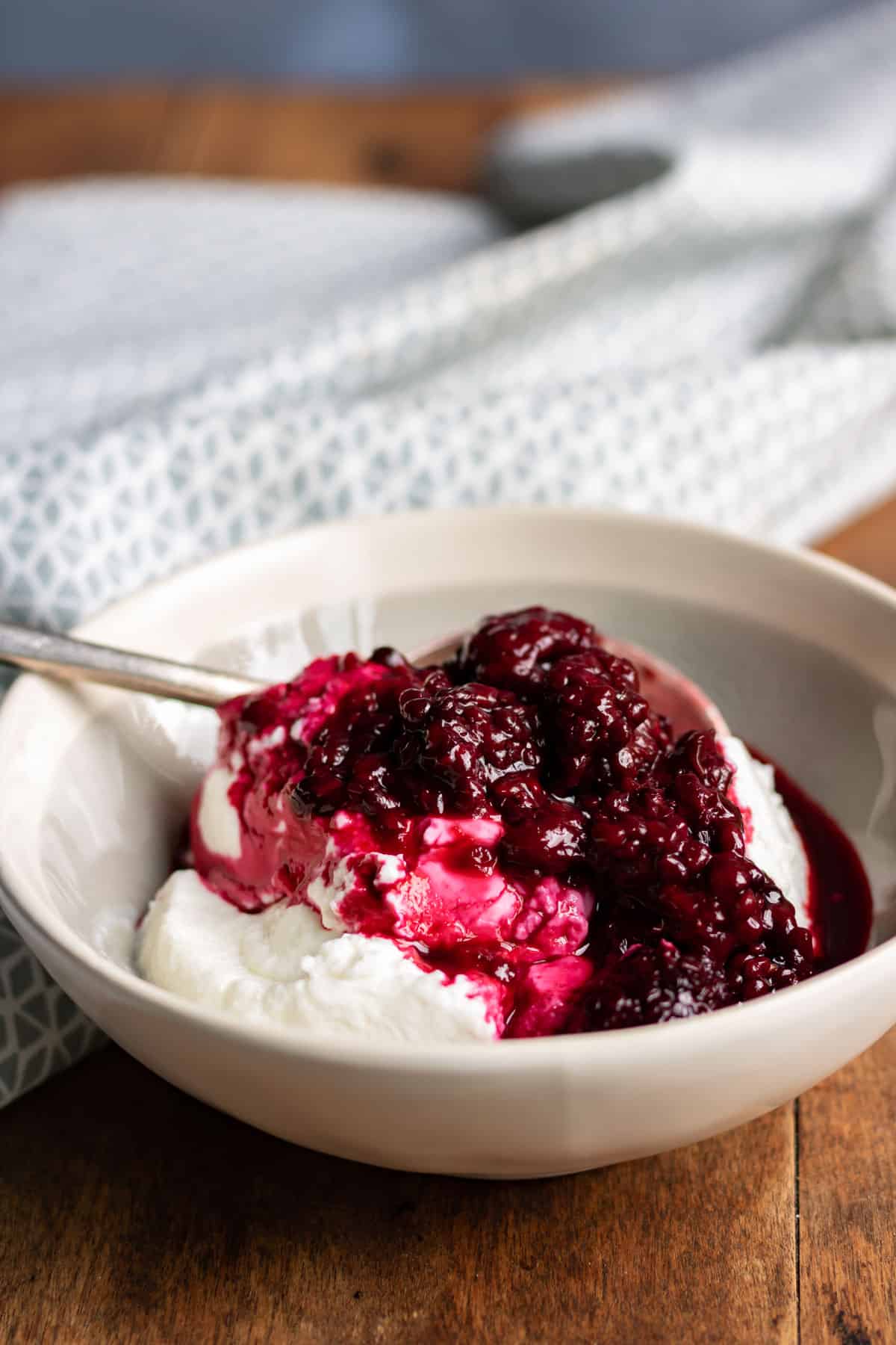Bowl of yogurt with blackberry compote sauce.