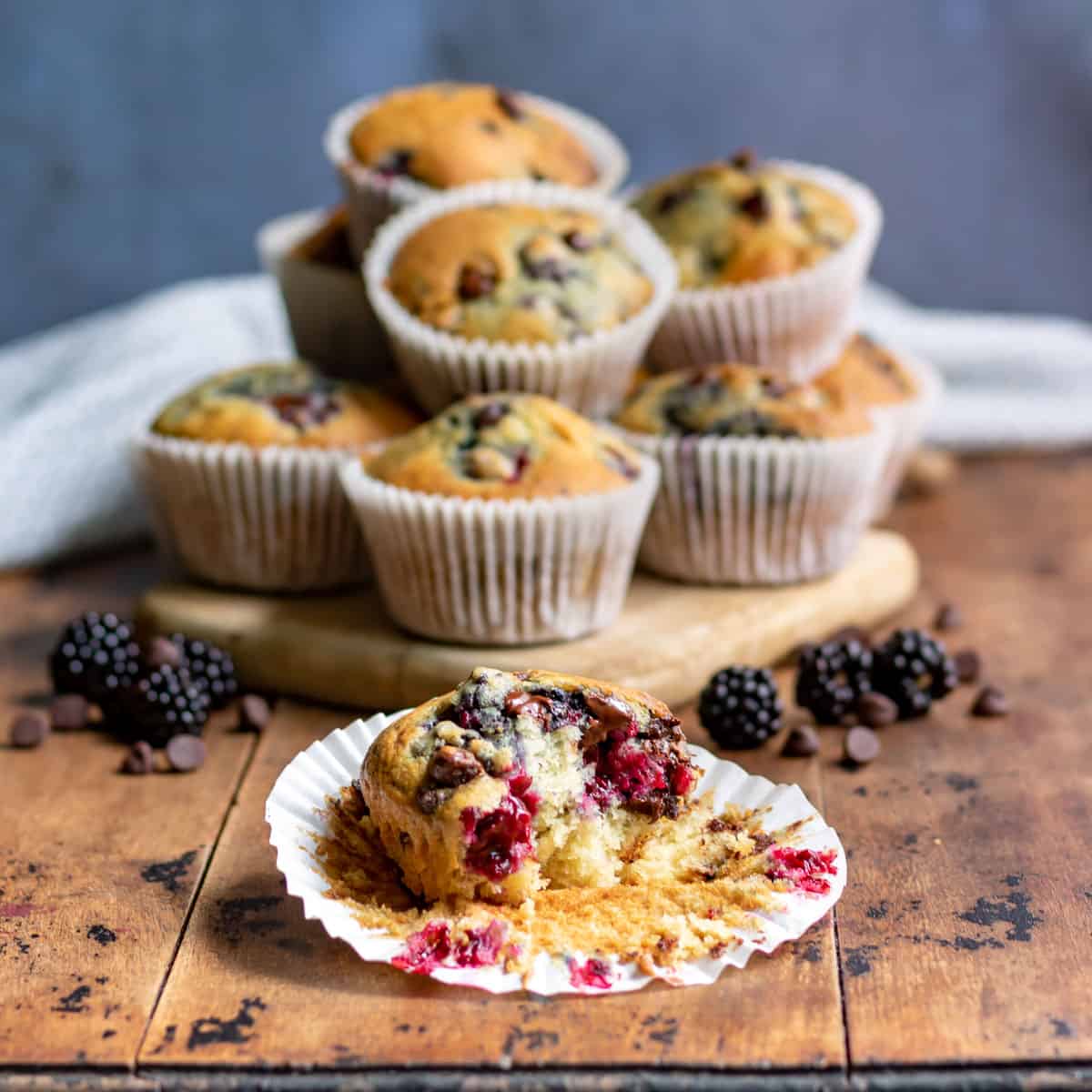 A pile of muffins with one in front with a bite out.
