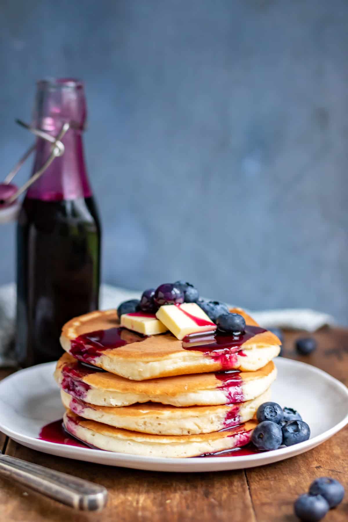 Stack of pancakes drizzled with syrup.