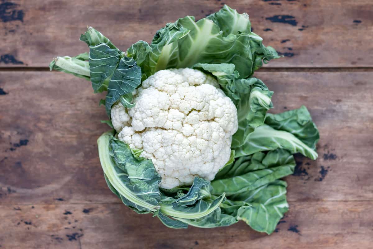 Whole cauliflower on a wooden table.