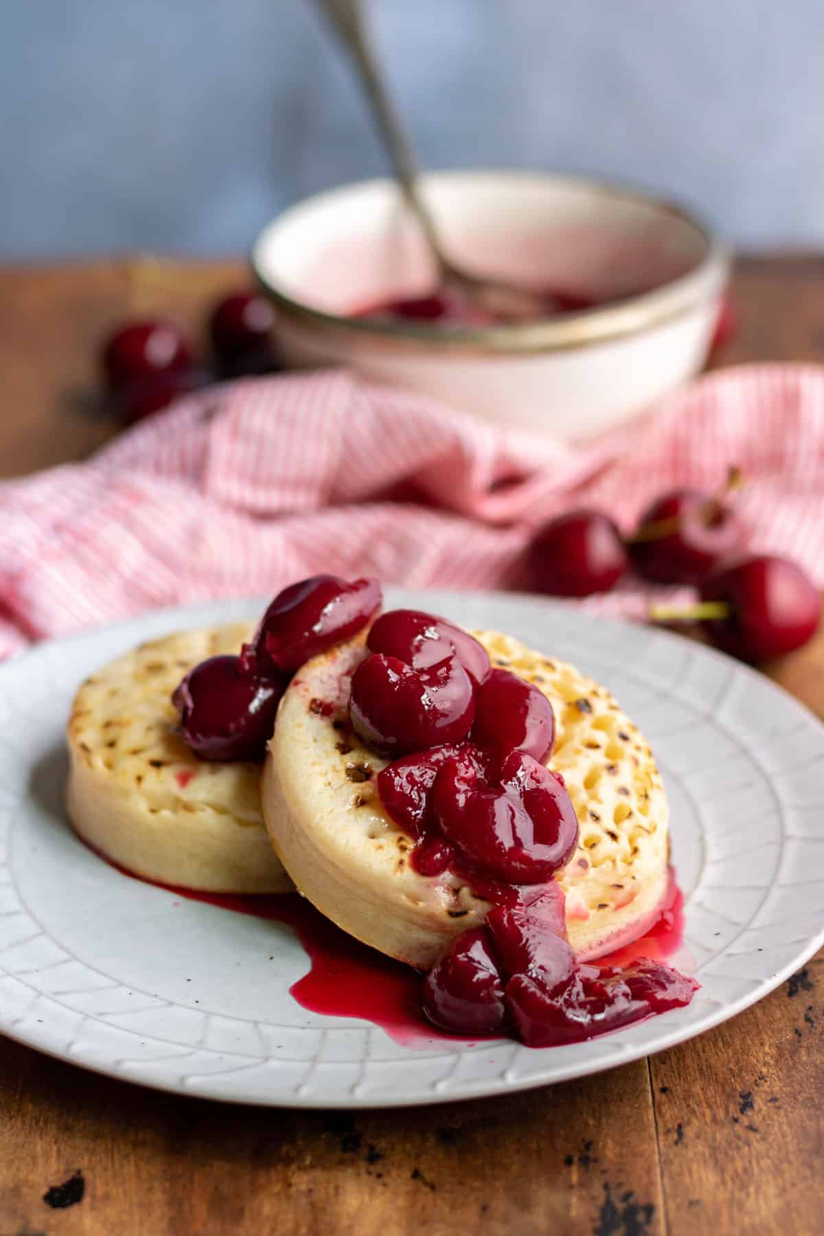 Plate of crumpets drizzled with cherry compote.