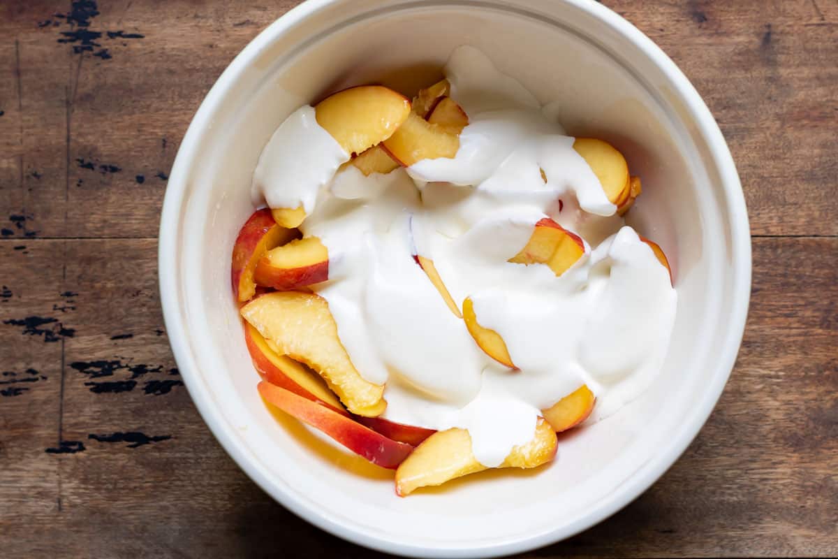 Bowl of peaches with cream poured in.