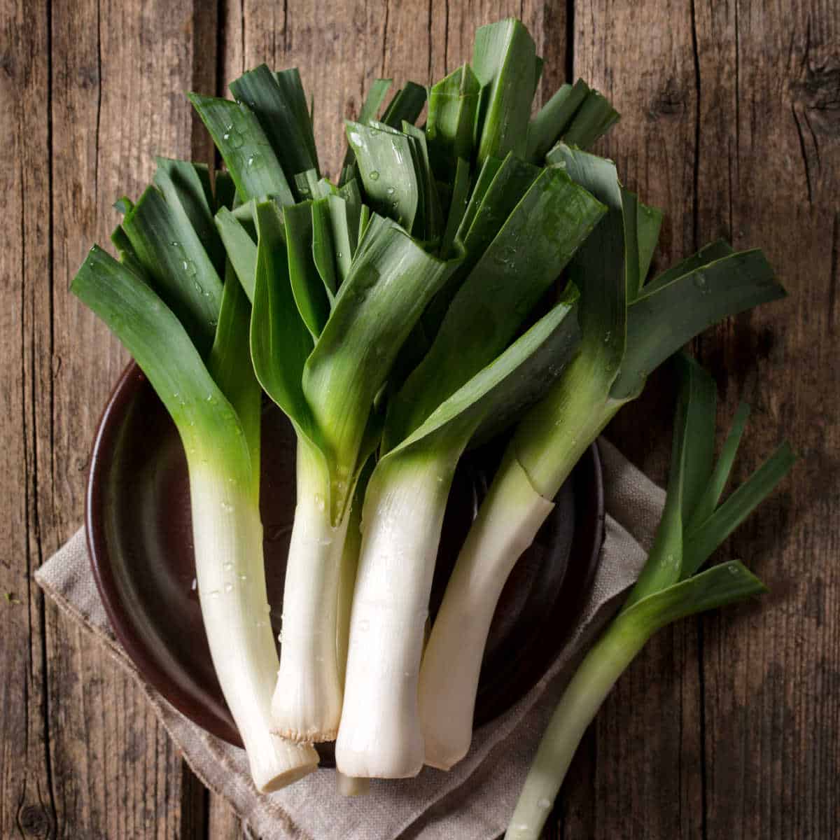 Leeks on a wooden table.