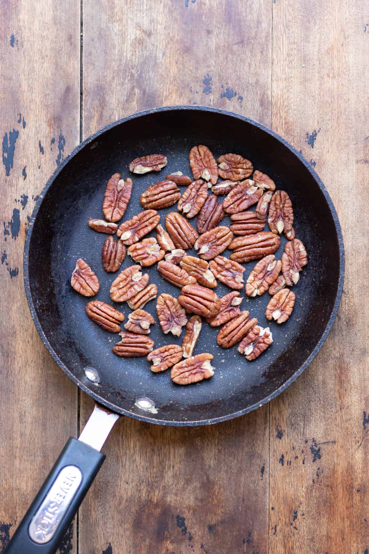 Toasting pecans in a frying pan.