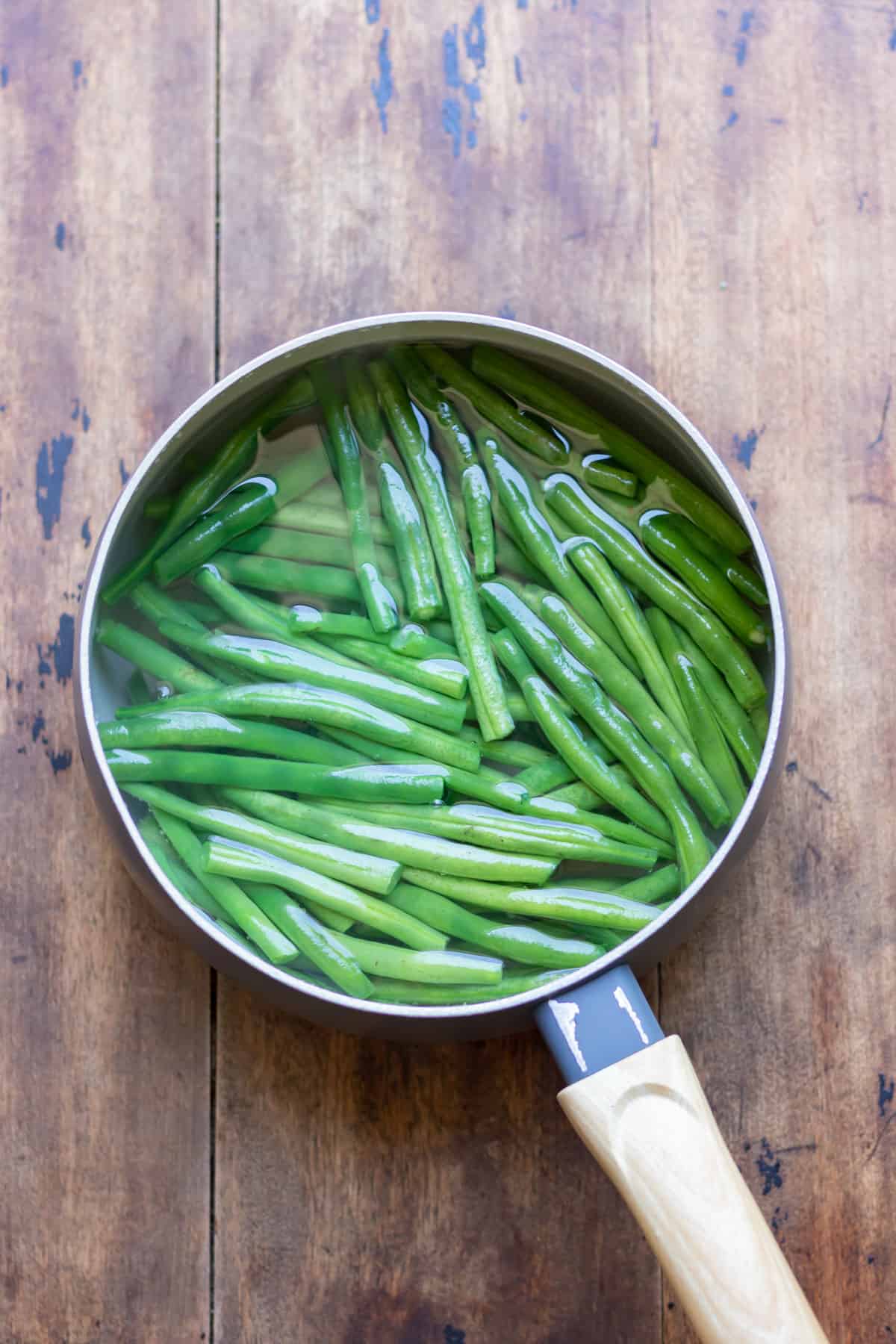 Blanching green beans in a pot of water.