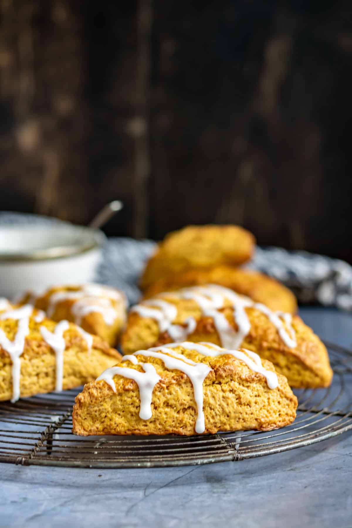 Close up of a pumpkin scone on a wire rack.