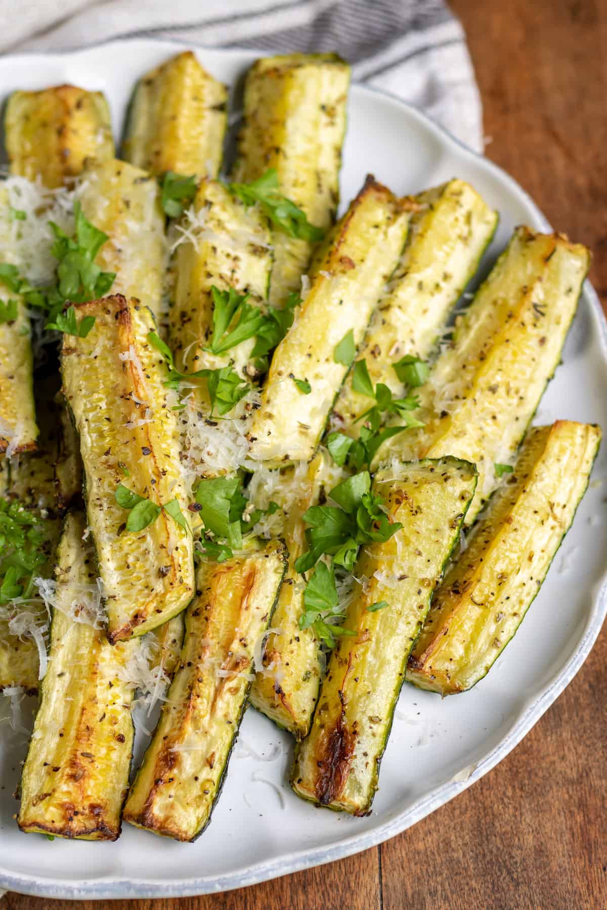 Close up of spears of roasted zucchini on a plate.