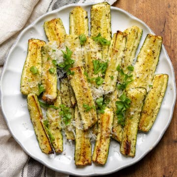 Serving dish of roasted zucchini with parmesan cheese.