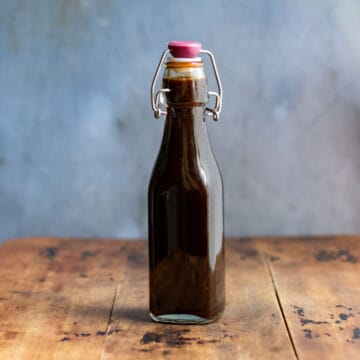 Bottle of sauce on a wooden table.