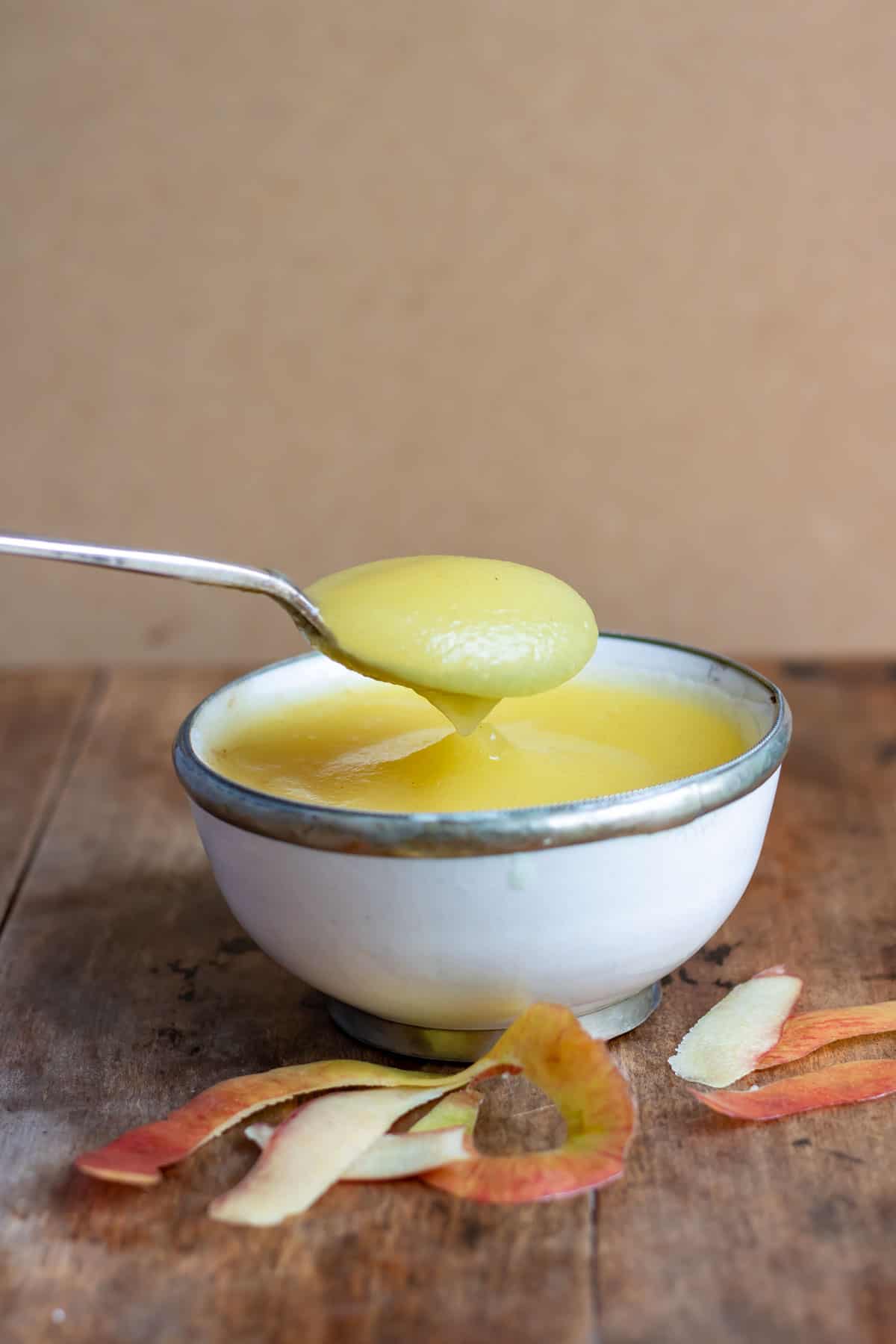 A spoonful coming out of a bowl of applesauce.