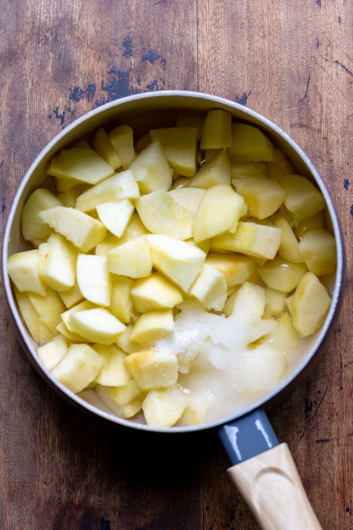 Pot with slices of apple and sugar.