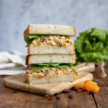 A stack of vegan chickpea sandwiches on a table.