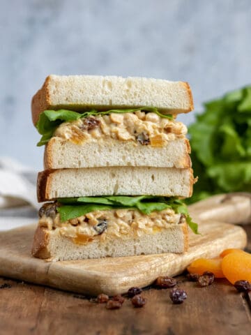A stack of vegan chickpea sandwiches on a table.