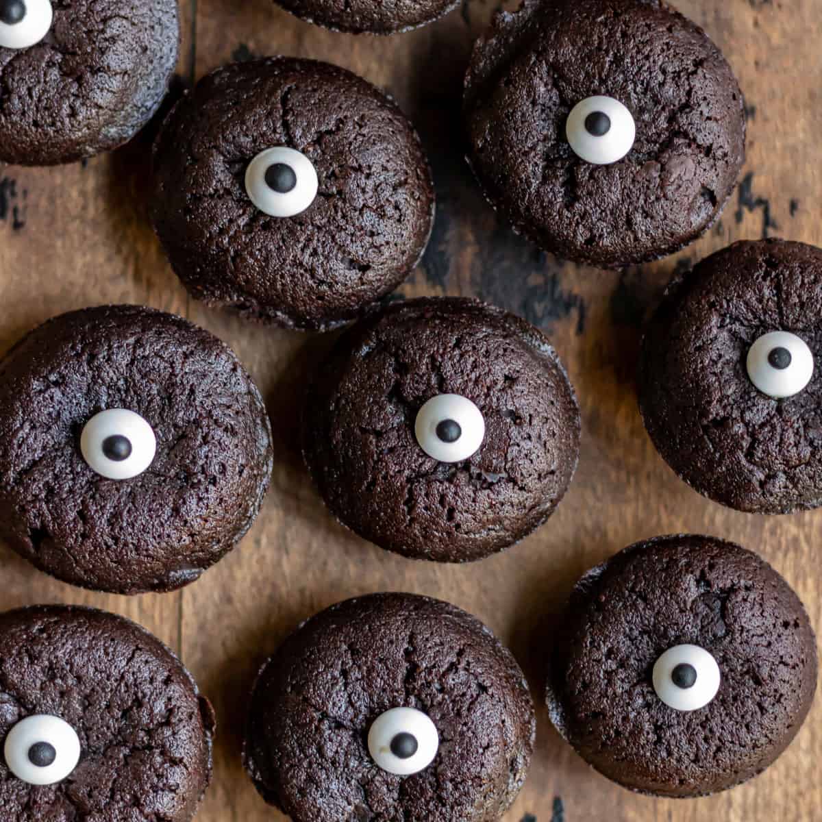 Rows of mini halloween brownie bites topped with candy eyes.